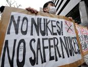 Members of various civic groups hold placards in Tokyo denouncing the use of nuclear power during a rally in front of the headquarters of Tokyo Electric Power Co. (TEPCO). Workers at Japan's crippled nuclear plant Sunday struggled to stop a radioactive water leak into the Pacific, as the government warned the facility may spread contamination for months