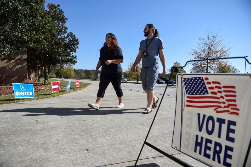 Brittany Teyer and Nick Schultz walk in to vote at Diamond Lakes on Tuesday, Nov. 8, 2022. 