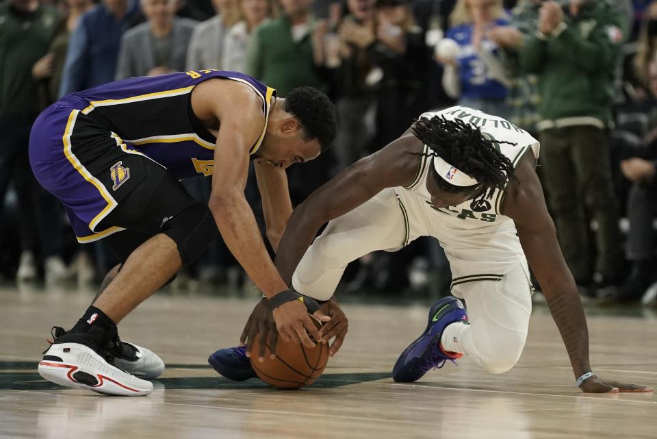 Milwaukee Bucks' Jrue Holiday and Los Angeles Lakers' Talen Horton-Tucker battle for a loose ball during the second half of an NBA basketball game Wednesday, Nov. 17, 2021, in Milwaukee. The Bucks won 109-102. (AP Photo/Morry Gash)