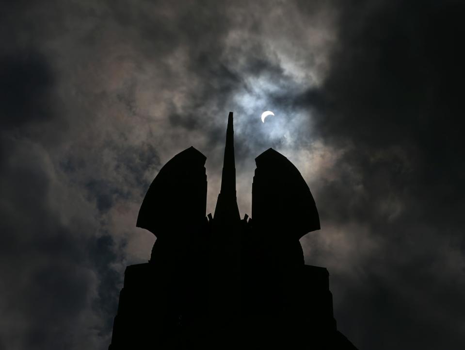 The solar eclipse reached its maximum amount of blockage at 2:35pm in downtown Rochester, seen over the "Wings of Progress" atop the Times Square Building Monday, Aug. 21, 2017.