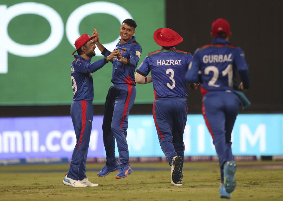 Afghanistan's Mujeeb Ur Rahman, third right, celebrates the wicket of Scotland's captain Kyle Coetzer during the Cricket Twenty20 World Cup match between Afghanistan and Scotland in Sharjah, UAE, Monday, Oct. 25, 2021. (AP Photo/Aijaz Rahi)