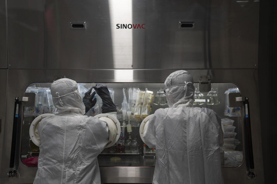 Workers labor in a lab at the SinoVac vaccine factory in Beijing on Thursday, Sept. 24, 2020. SinoVac, one of China's pharmaceutical companies behind a leading COVID-19 vaccine candidate says its vaccine will be ready by early 2021 for distribution worldwide, including the U.S. (AP Photo/Ng Han Guan)