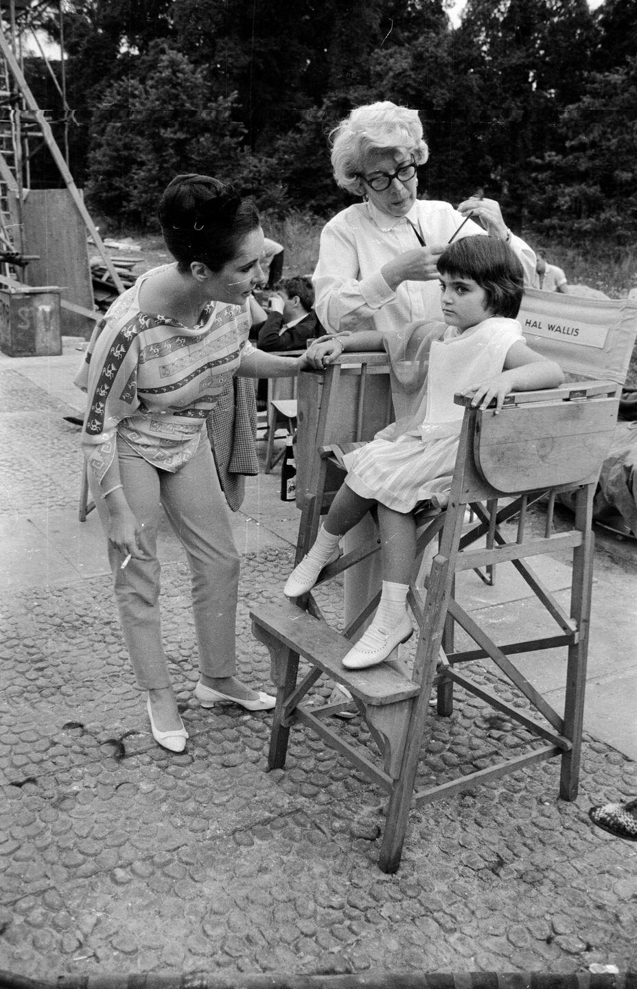 <p>While on the set of her mother Elizabeth Taylor's film <em>Becket, </em>Liza Todd gets her hair cut and styled by the film's hairdresser. We were getting our hair cut by our mothers over the bathroom sink at that age ...</p>