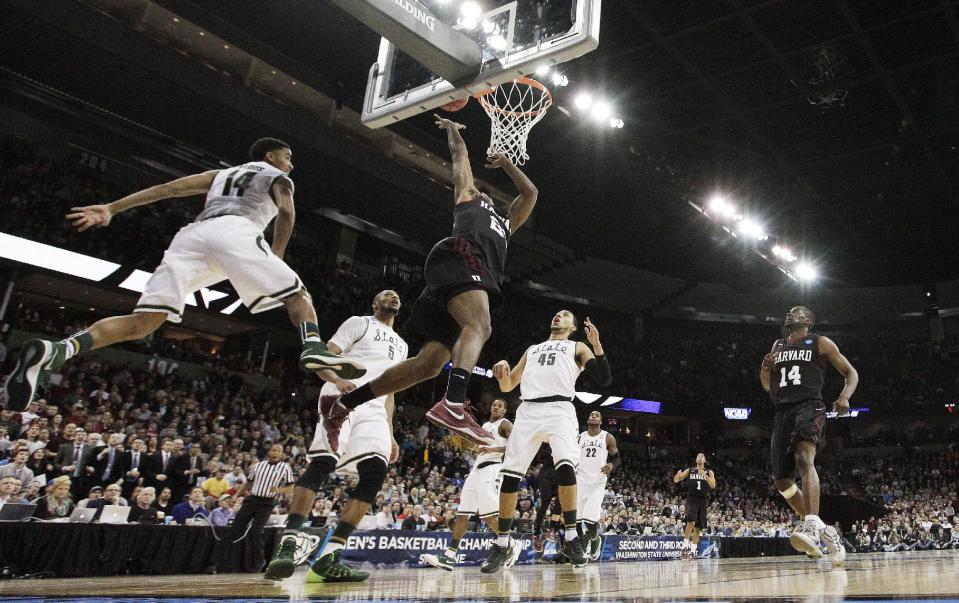 Harvard’s Wesley Saunders (23) shoots against Michigan State’s Gary Harris (14) in the second half during the third-round game of the NCAA men's college basketball tournament in Spokane, Wash., Saturday, March 22, 2014. Michigan State won 80-73. (AP Photo/Young Kwak)