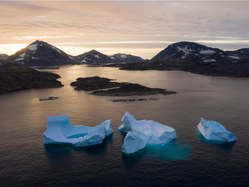 FILE - In this Aug. 16, 2019, file photo, large icebergs float away as the sun rises near Kulusuk, Greenland. Rising temperatures and diminished snow and ice cover in the Arctic are imperiling ecosystems, fisheries and local cultures, according to a report issued Tuesday, Dec. 10 by the National Oceanic and Atmospheric Administration.  (AP Photo/Felipe Dana, File)