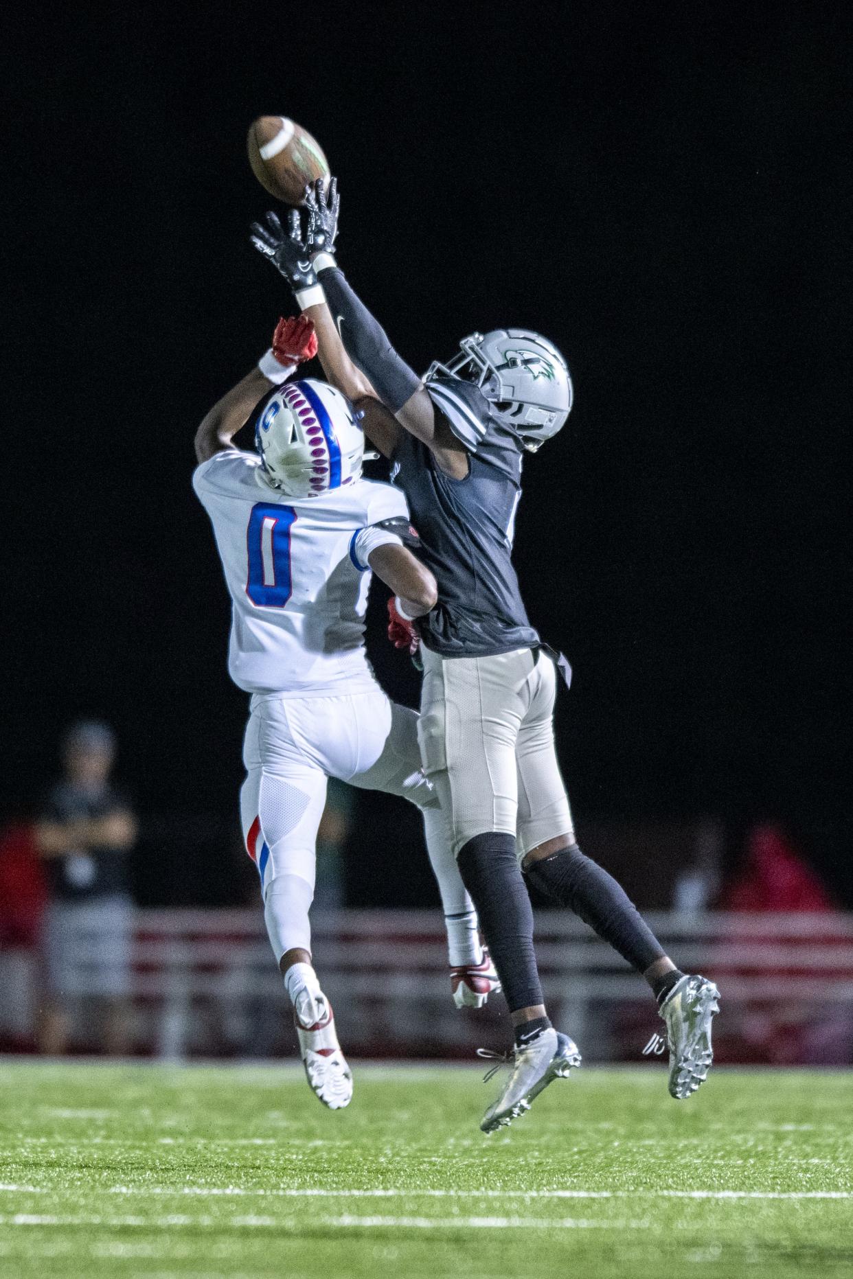 Zionsville High School junior Eugene Hilton (2) reaches over the defense of Hamilton Southeastern High School senior Donovan Rhodes (0) to pull in a reception during the second half of an IHSAA varsity football game, Friday, Sept. 22, 2023, at Zionsville High School.