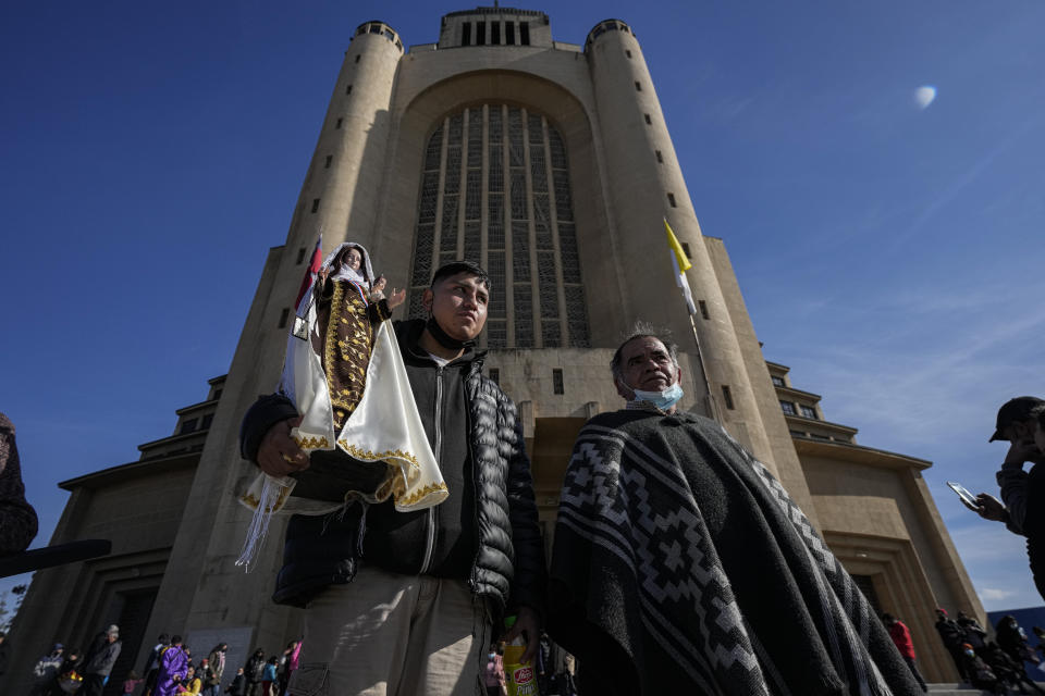 A man carries a statue of the Virgin del Carmen, patron saint of Chile, during a celebration in honor of her feast day, in Santiago, Chile, Saturday, July 16, 2022. Hundreds of cowboys in woolen ponchos and families on wooden horse carts lined up to receive a priest's blessing in the huge esplanade in front of the National Sanctuary of Maipu on Saturday afternoon. (AP Photo/Esteban Felix)