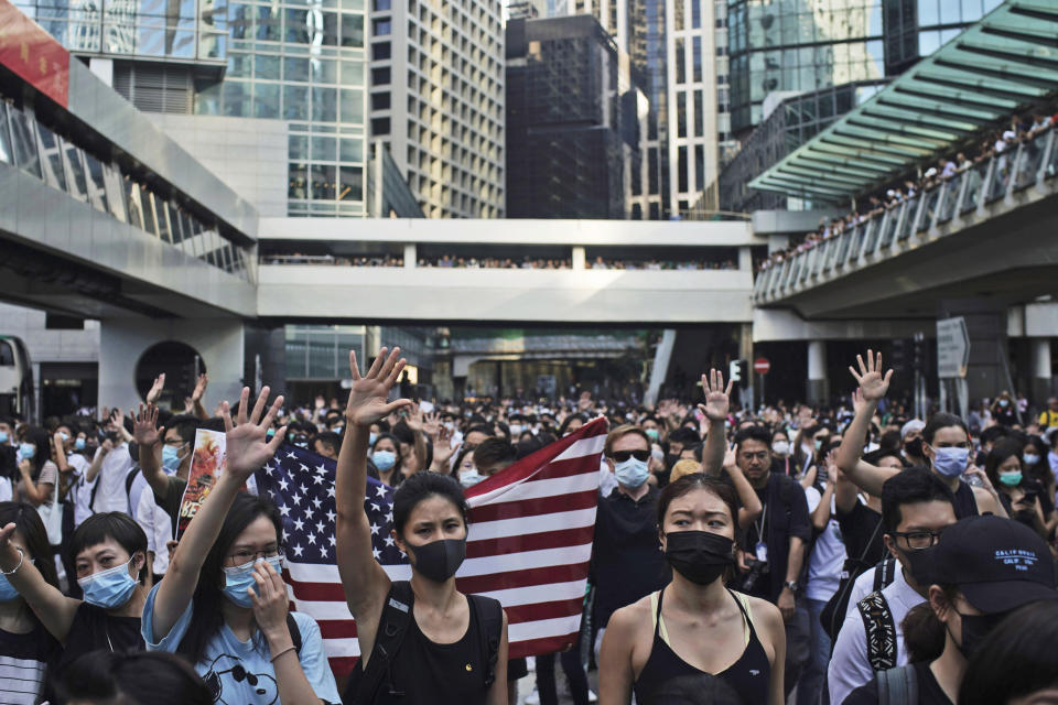 Protesters wear masks and hold up their hands to represent their five demands in Hong Kong Friday, Oct. 4, 2019. Hong Kong pro-democracy protesters marched in the city center Friday ahead of plans by the city's embattled leader to deploy emergency powers to ban people from wearing masks in a bid to quash four months of anti-government demonstrations. (AP Photo/Felipe Dana)