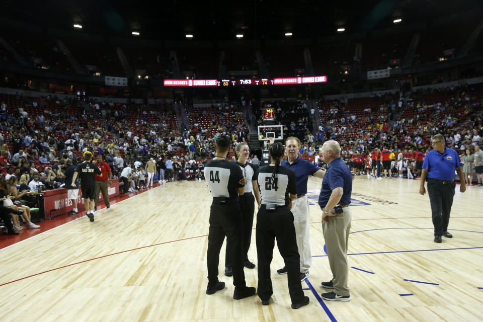 Officials confer after an NBA summer league basketball game between the New York Knicks and the New Orleans Pelicans was stopped due to an earthquake Friday, July 5, 2019, in Las Vegas. (AP Photo/Steve Marcus)