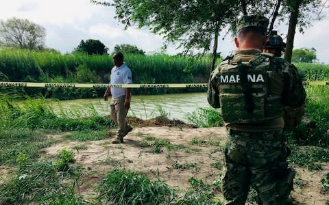 Mexican authorities walk along the Rio Grande bank where the bodies of Salvadoran migrant Oscar Alberto Marti­nez Rami­rez and his nearly 2-year-old daughter Valeria - Credit: Julie Le Duc