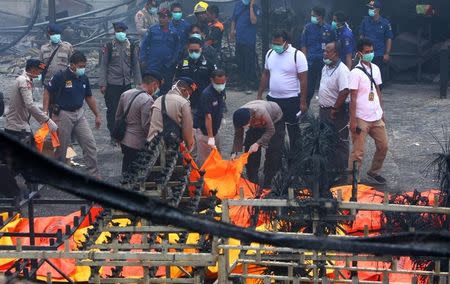 Indonesian police officers check dead bodies after an explosion at a fireworks factory at Kosambi village in Tangerang, Banten province, Indonesia October 26, 2017. Antara Foto/Muhammad Iqbal via REUTERS