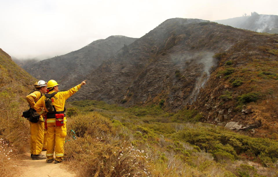 Firefighters from El Dorado Hills keep watch on a smoldering cliff at Garrapata State Park during the Soberanes Fire north of Big Sur, Calif., July 31, 2016. (REUTERS/Michael Fiala)