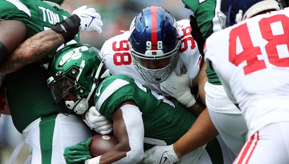 EAST RUTHERFORD, NEW JERSEY - AUGUST 28: Running back Breece Hall #20 of the New York Jets carries the ball as defensive tackle D.J. Davidson #98 of the New York Giants tackles during the 1st half of the preseason game at MetLife Stadium on August 28, 2022 in East Rutherford, New Jersey. (Photo by Jamie Squire/Getty Images)