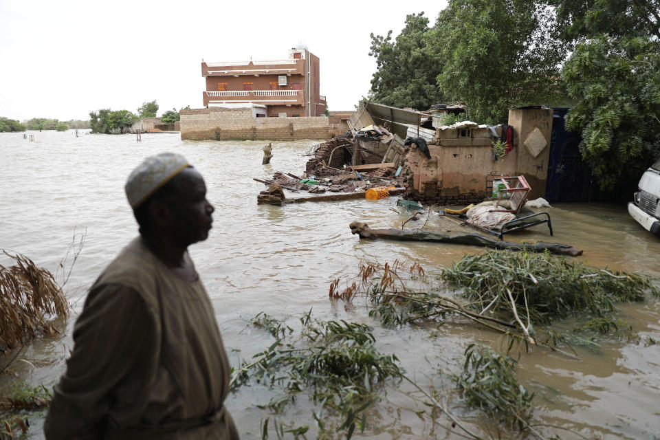 A man passes on the side of a flooded road in the town of Shaqilab, about 15 miles (25 km) southwest of the capital, Khartoum, Sudan, Monday, Aug. 31, 2020. (AP Photo/Marwan Ali)