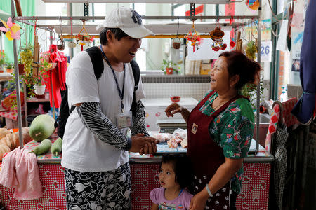 Chen Hong-zhi, 26, who suffers from short-term memory loss, smiles as he talks with his neighbour at a market near Beipu Old Street area in Hsinchu, Taiwan, September 26, 2018. REUTERS/Tyrone Siu