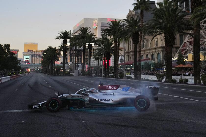 George Russell does a burnout during a demonstration along the Las Vegas Strip at a launch party for the Formula One Las Vegas Grand Prix, Saturday, Nov. 5, 2022, in Las Vegas. (AP Photo/John Locher)