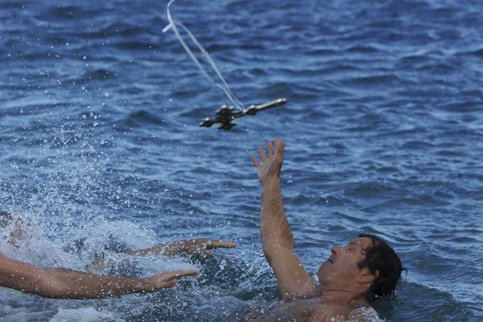 Swimmers try to catch the cross thrown by an Orthodox priest into the water, during an epiphany ceremony to bless the sea at Famagousta in the abandoned city in the Turkish Cypriot breakaway north part of the eastern Mediterranean divided island of Cyprus, Monday, Jan. 6, 2020. Many Orthodox Christian faithful attended the Epiphany Day blessing of the waters in Famagusta in Cyprus, the fifth time the ceremony has taken place since 1974 when the small island nation was cleaved along ethnic lines. (AP Photo/Petros Karadjias)