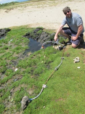 Pete Barry, a geochemist at the University of Oxford, takes gas samples from a thermal pool at a helium prospecting site in Tanzania operated by Norwegian geoscience company Helium One.