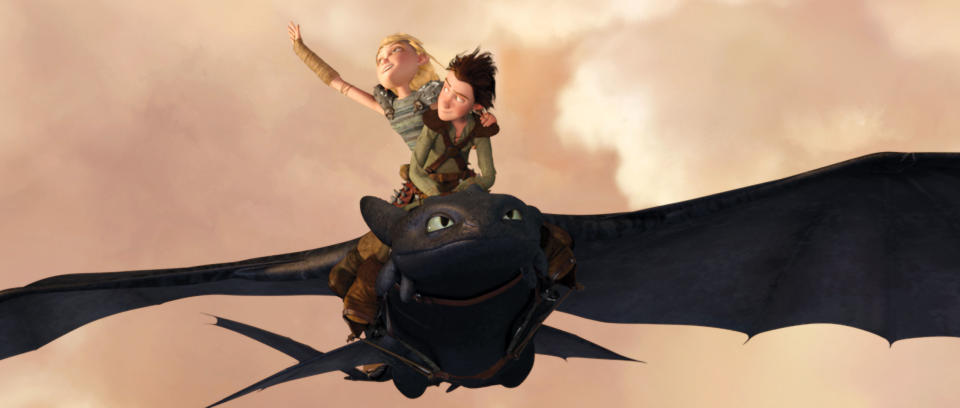 Astrid and Hiccup fly on Toothless in a scene from "How to Train Your Dragon." Astrid raises her arm triumphantly, while Hiccup steers the dragon