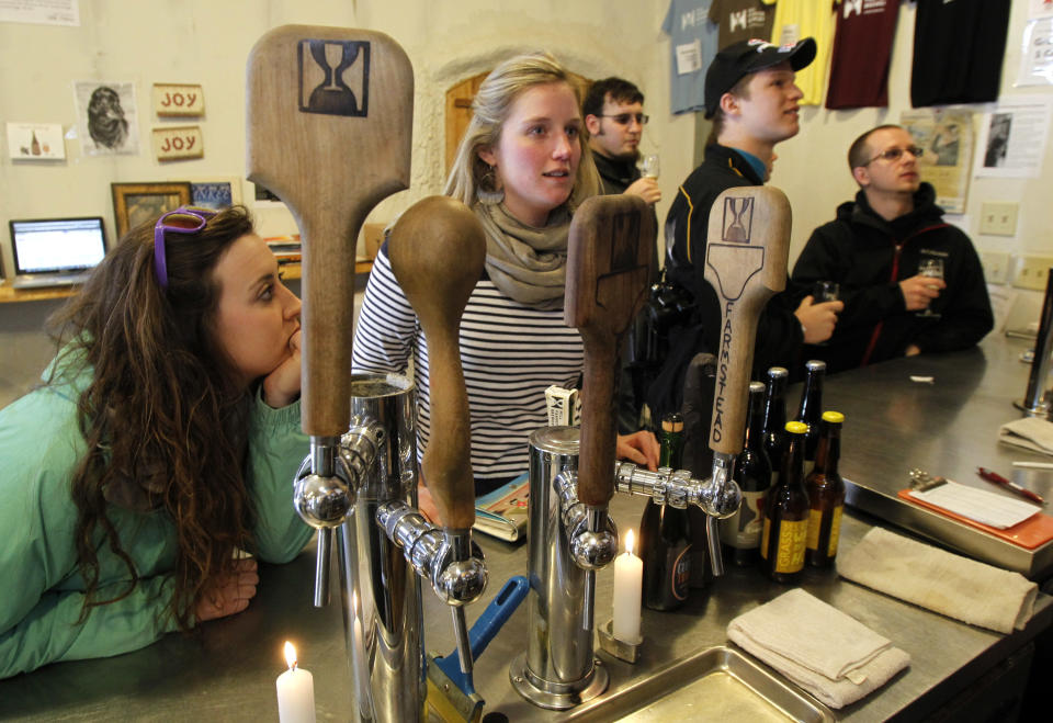 In this Wednesday, April 3, 2013 photo, customers line the bar at Hill Farmstead Brewery in Greensboro, Vt. Vermonters are buzzing about beer, and with good reason. The craft brew world has noticed that the small New England state better known for its cheeses and maple syrup also happens to make killer beer. In fact, one brewery, Hill Farmstead Brewery, has been rated the world's best brewer on a popular international consumer review website called RateBeer.com. (AP Photo/Toby Talbot)