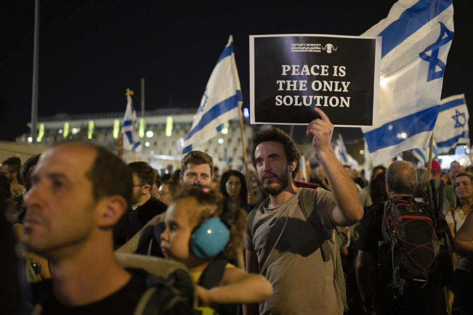 A man holds up a sign during a protest against Israeli Prime Minister Benjamin Netanyahu's government and to call for the release of hostages held in the Gaza Strip by the Hamas militant group near the Knesset, Israel's parliament, in Jerusalem, Monday, April 1, 2024. (AP Photo/Leo Correa)