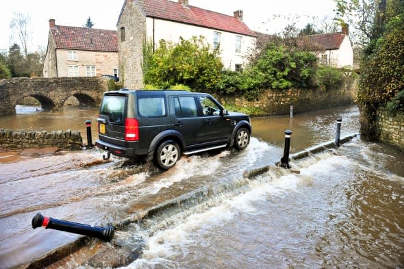 Land Rover Discovery drives through a flood