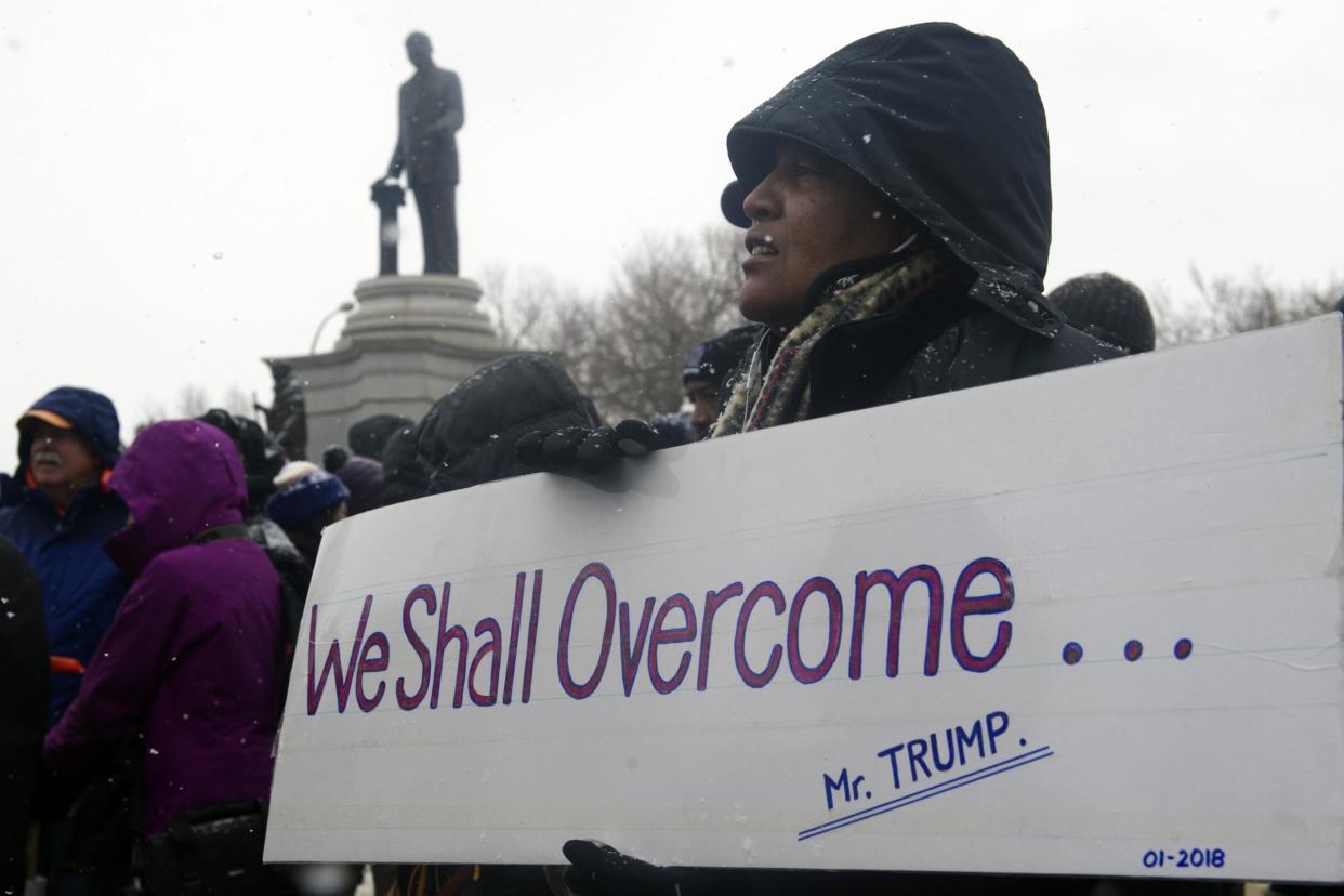 Lesa Webb of Los Angeles, California, holds up a sign before marching in the 32nd Annual Martin Luther King, Jr march and parade in Denver, Colorado: JASON CONNOLLY/AFP/Getty Images