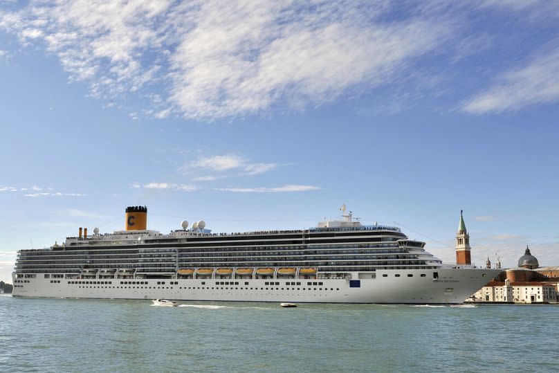 In this file photo, the Costa Deliziosa cruise ship sails past St. Mark's Square, visible in background at right, in Venice, Italy