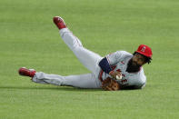 Los Angeles Angels' Brian Goodwin falls to the ground after fielding a sacrifice fly by Texas Rangers' Robinson Chirinos in the second inning of a baseball game in Arlington, Texas, Friday, Aug. 7, 2020. The Rangers' Willie Calhoun scored on the play. (AP Photo/Tony Gutierrez)