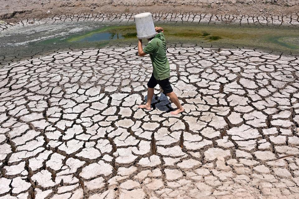 March 19, 2024: A man carries a plastic bucket across the cracked bed of a dried-up pond in Vietnam's southern Ben Tre province. Every day, farmer Nguyen Hoai Thuong prays in vain for rain to fall on the cracked, dry earth of her garden in Vietnam's Mekong Delta -- the country's "rice bowl" agricultural heartland. A blazing month-long heatwave has brought drought, parching the land in Thuong's home of Ben Tre province, 130 kilometers (80 miles) south of business hub Ho Chi Minh City.