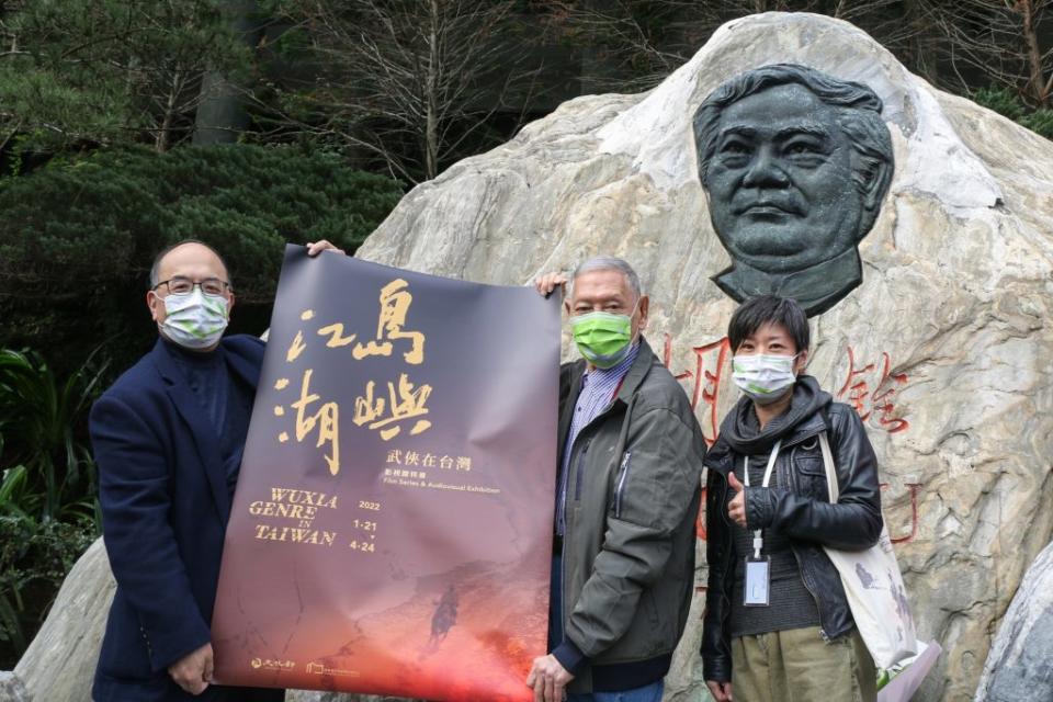 國家電影及視聽文化中心將舉辦「島嶼江湖」特展，其中包含已故名導胡金銓系列作品，國家影視聽中心董事長藍祖蔚（左）、執行長王君琦（右）與亞太影帝石雋（中）到胡金銓紀念碑分享消息。（國家影視聽中心提供／中央社）