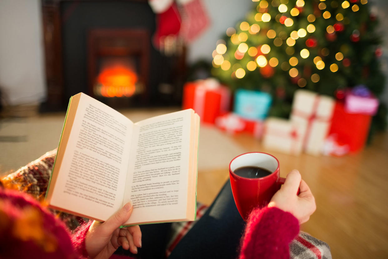 Reading a book and drinking coffee at Christmas Getty Images/Wavebreakmedia