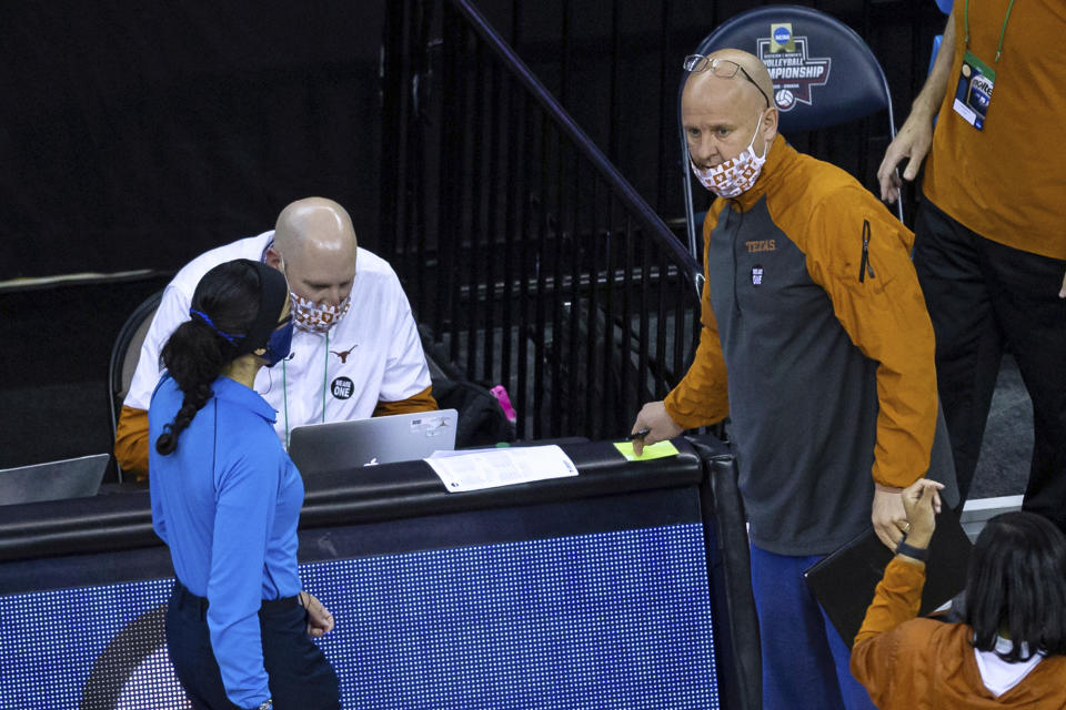 FILE - In this April 22, 2021, file photo, Texas coach Jerritt Elliott grabs the green card to challenge what became the last point in the third set against Wisconsin during a semifinal in the NCAA women's volleyball championships in Omaha, Neb. As the No. 1 team in the American Volleyball Coaches Association preseason poll, Texas is expected to be back in the national final for the fourth time in seven years. (AP Photo/John Peterson, File)
