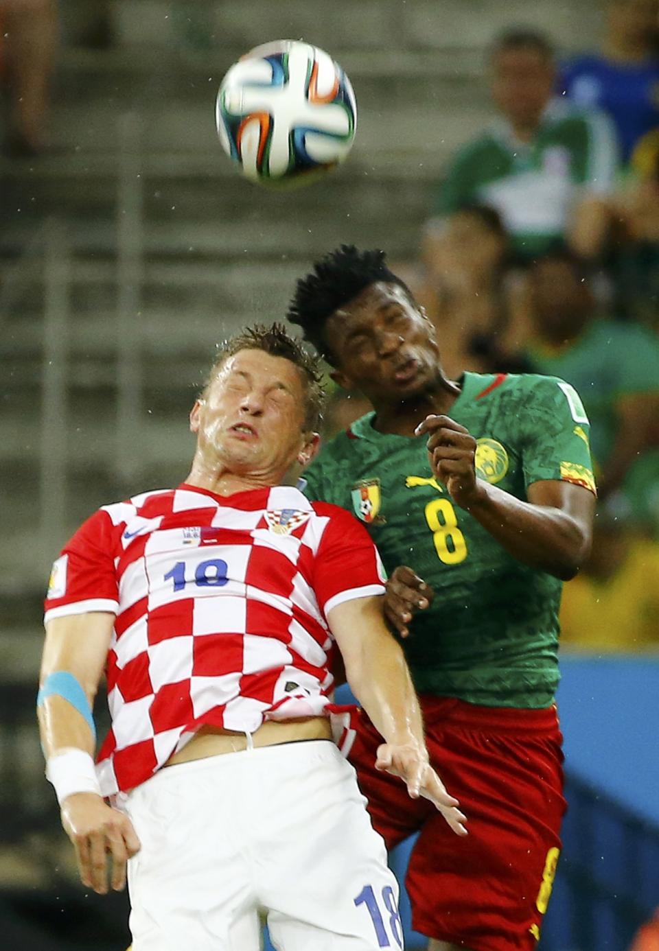 Croatia's Ivica Olic jumps for the ball with Cameroon's Benjamin Moukandjo during their 2014 World Cup Group A soccer match at the Amazonia arena in Manaus June 18, 2014. REUTERS/Murad Sezer