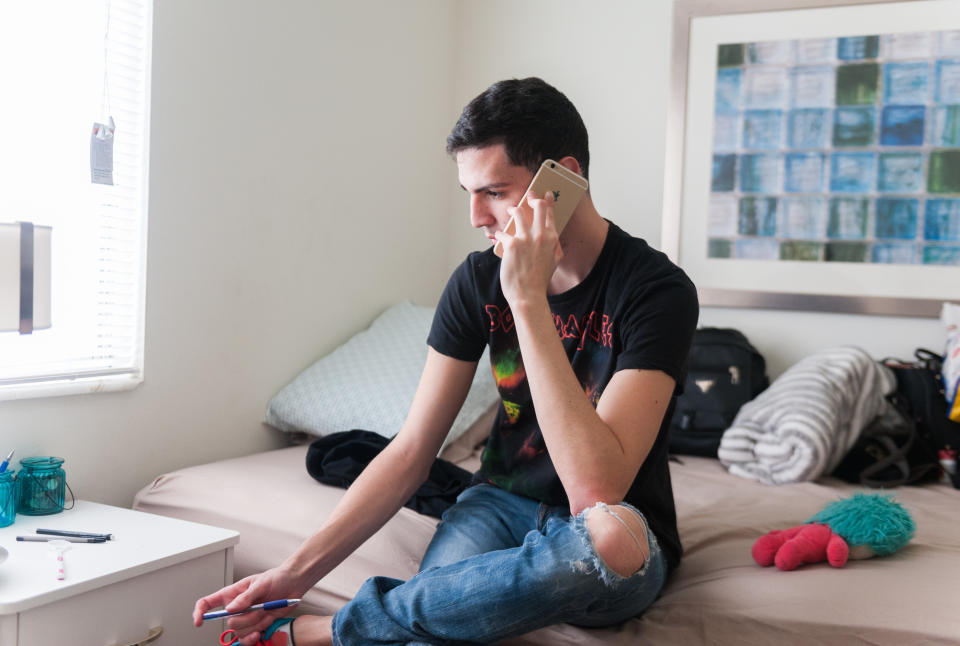 Jan Miguel talks on the phone&nbsp;at&nbsp;his temporary apartment. (Photo: Chris McGonigal/HuffPost)