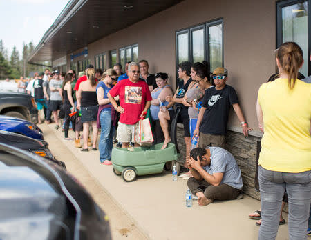 Residents of Fort McMurray line up outside a grocery store after they were ordered to be evacuated due to a raging wildfire, in Anzac, Alberta, Canada May 4, 2016. REUTERS/Topher Seguin