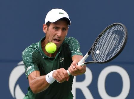 FILE PHOTO: Aug 7, 2018; Toronto, Ontario, Canada; Novak Djokovic of Serbia plays a shot against Mirza Basic of Bosnia and Herzegovina (not shown) in the Rogers Cup tennis tournament at Aviva Centre. Mandatory Credit: Dan Hamilton-USA TODAY Sports