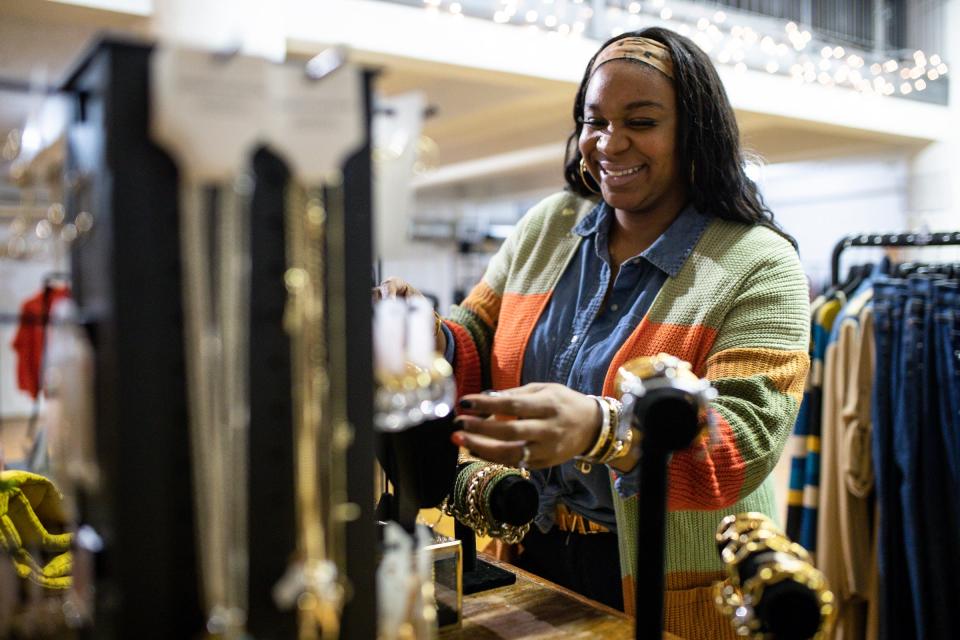 Daisha McKenzie who owns the brand Trinkets and Such adjusts display of her section inside of the By Popular Demand The Collective in Detroit on Thursday, Nov. 11, 2021.