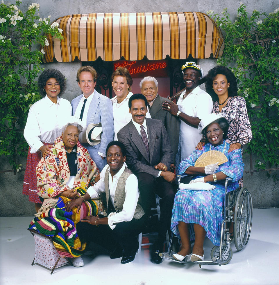 The cast of the CBS television situation comedy 'Frank's Place,' (back row, from left) Francesca P. Roberts (as Anna-May), Robert Harper (as Sy 'Bubba' Weisburger), Don Yesso (as Shorty), Charles Lampkin (1913 - 1989) (as Tiger), Tony Burton (as Big Arthur), and Daphne Maxwell Reid (as Hannah Griffin) and (front row, from left) Frances E. Williams (1905 - 1995) (as Miss Marie), William Thomas, Jr. (as Cool Charles), Tim Reid (on stool, as Frank Parrish), and Virginia Capers (1925 - 2004) (as Bertha Griffin) pose for a promotional photograph on the set in front of an entranceway under an awning, Southern California, 1987. (Photo by CBS Photo Archive/Getty Images)