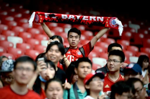 Un hincha del Bayern Múnich con una bufanda del equipo alemán mientras asiste a un entrenamiento en el Estadio Olímpico o &#39;Nido de Pájaro&#39;, en Pekín el 17 de julio de 2015, la víspera de su encuentro con el Valencia español (AFP | Wang Zhao)