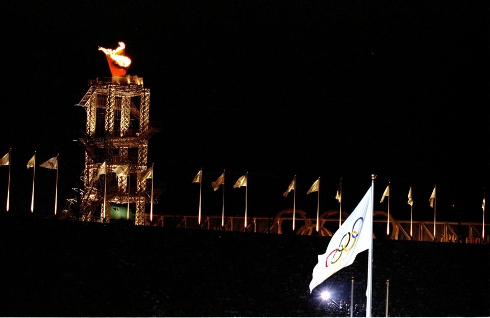 The Olympic flag flies in fromt of the Olympic Flame during the Closing Ceremony of the 1996 Centennial Olympic Games at Olympic Stadium in Atlanta, Georgia.