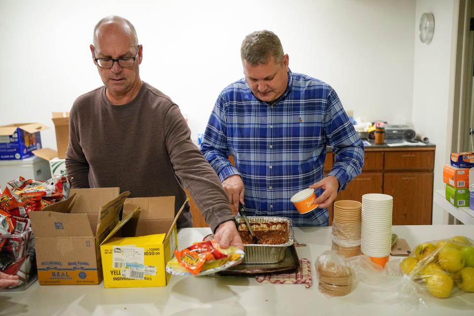 Bruce Reinhart, left, and Bruce Moore, volunteers for "The Largest Table," serve lunch at Trinity Episcopal Church after the weekly Wednesday meal for the hungry moved from St. John's United Church of Christ due to the sale of the latter's Mound Street church.