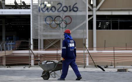 A worker walks in front of the Olympic aquatic venue for the Rio 2016 Olympic Games during the third media briefing for the Games in Rio de Janeiro, Brazil, October 6, 2015. REUTERS/Sergio Moraes