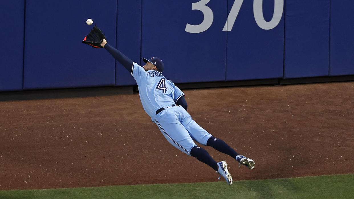 NEW YORK, NY - JULY 24: George Springer #4 of the Toronto Blue Jays makes a diving catch on a ball off the bat of Brandon Nimmo #9 of the New York Mets during the third inning at Citi Field on July 24, 2021 in New York City. (Photo by Adam Hunger/Getty Images)