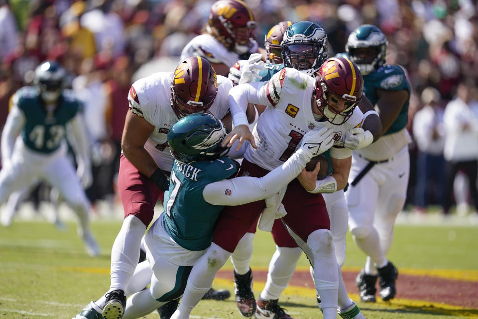 Washington Commanders quarterback Carson Wentz (11) is sacked by Philadelphia Eagles linebacker Haason Reddick (7) and defensive end Brandon Graham (55) during the first half of NFL football game, Sunday, Sept. 25, 2022, in Landover, Md. (AP Photo/Alex Brandon)