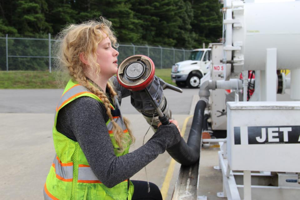 Madeline Tate, seen on the job Tuesday Aug. 2, 2022 at Portsmouth International Airport at Pease, is one of the many line service techs at Port City Air, whose job is to keep the planes that fly in and out of the airport fueled, maintained and ready to fly. That often involves working in extreme heat, made hotter by the sea of pavement at the airport.