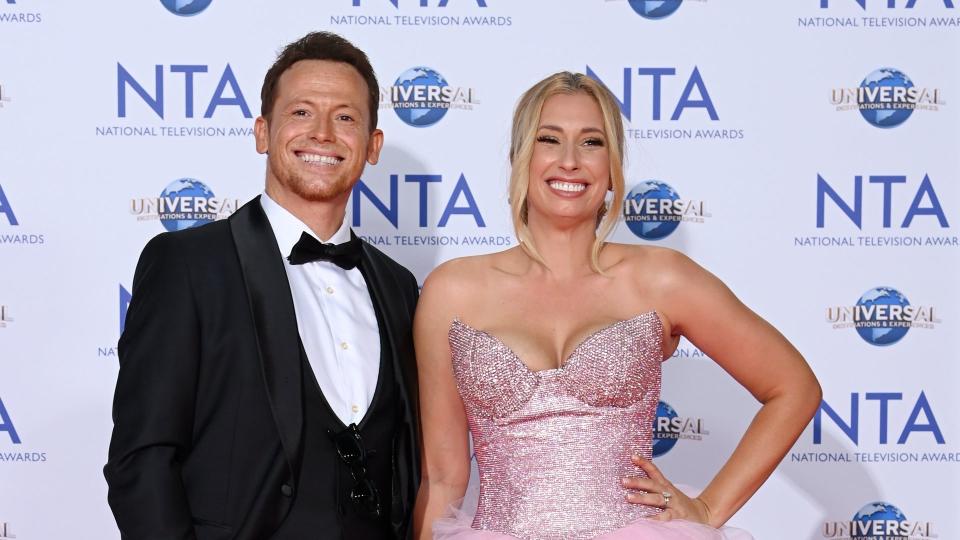 Joe Swash in tuxedo stood next to Stacey Solomon in pink dress