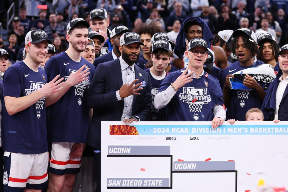 The Connecticut Huskies celebrate after defeating the Illinois Fighting Illini in the Elite 8 round of the NCAA Men's Basketball Tournament at TD Garden on March 30, 2024 in Boston, Massachusetts.