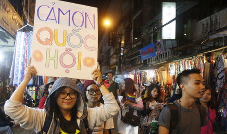 A member of LGBT (lesbian, gay, bisexual and transgender) community holds a placard which reads thanks to National Assembly during a demonstration along a street in Hanoi, Vietnam November 24, 2015. REUTERS/Kham