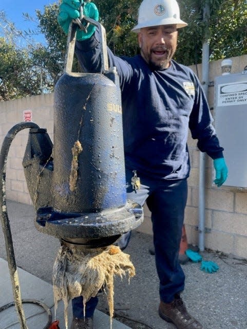 Hector Banos, a wastewater service worker with the Ventura County Water and Sanitation Department, holds a tangle of wipes and rags in a submersible pump at the Nyeland Acres lift station in October.